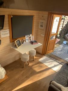 TINY HOUSE & SPA في Faycelles: غرفة معيشة مع طاولة بيضاء وتلفزيون