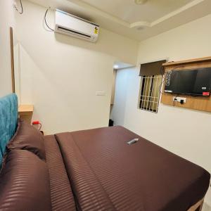 een kamer met een bank en airconditioning aan de muur bij Sundaram Residency in Chennai