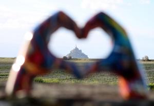 une vue en forme de cœur d'un bâtiment dans un champ dans l'établissement Vue unique sur le Mont St Michel, à Huisnes-sur-Mer