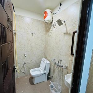 een badkamer met een toilet en een wastafel bij Sundaram Residency in Chennai
