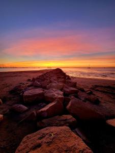 a group of rocks on the beach at sunset at Studio 237 Port Camargue, Piscine, Climatisation, 2 personnes in Le Grau-du-Roi
