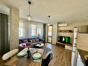 uma sala de estar com uma mesa e um sofá em Joy Apartment Burgas center private parking em Burgas