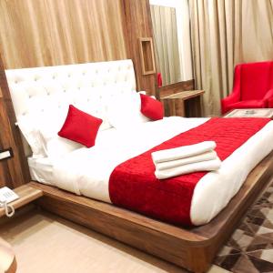 a bedroom with a large bed with red pillows at Grand Hill mall road Mcleodganj in Dharmsala