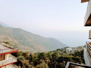 a view of a city with mountains in the background at Grand Hill mall road Mcleodganj in Dharmsala