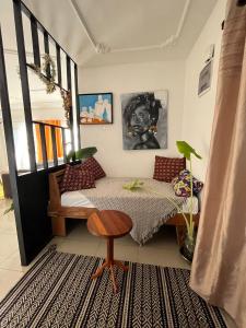 a bedroom with a bed and a table and a stool at Galerie d'hôte la Martine in Kribi
