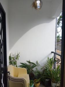 a balcony with a chair and some plants at Galerie d'hôte la Martine in Kribi