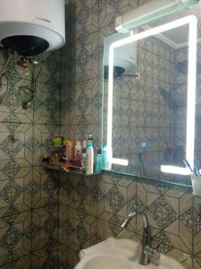 a bathroom with a sink and a mirror at Galerie d'hôte la Martine in Kribi