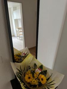 a mirror with a bouquet of yellow flowers in it at Zurich 2 Bedrooms Apartment in Zürich