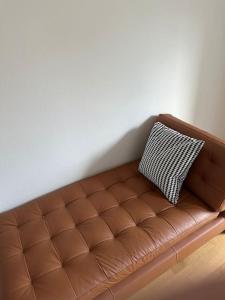 a brown leather couch with a black and white pillow at Zurich 2 Bedrooms Apartment in Zürich