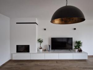 a living room with a flat screen tv and a black ceiling at Hele gezinswoning met zwembad te huur in Mechelen