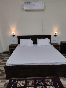 a large bed in a room with two night stands at Atithi home stay in Rāmnagar