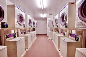 eine Waschküche mit vielen Waschmaschinen in Regalen in der Unterkunft Okayama Universal Hotel Annex 2 in Okayama