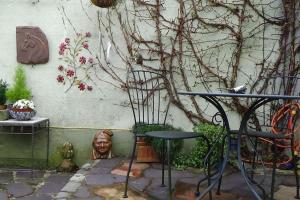 eine Terrasse mit einem Tisch und einer Statue neben einer Wand in der Unterkunft The Weaver's Cottage in Dungannon