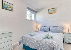 a bedroom with a bed with blue pillows at Coverack Cottage in Saint Keverne