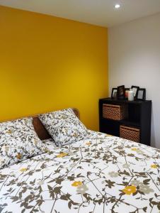 a bedroom with a bed and a yellow wall at L'Appart in La Chapelle-aux-Bois