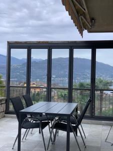 una mesa y sillas en un balcón con vistas en Serenellasullago, en Baveno