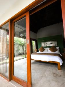 a bedroom with a bed and a large glass door at Dolce Magia in Gili Trawangan