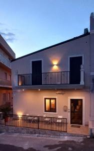 a white building with a balcony on top of it at B&B L'Antica Torre in Pozzallo