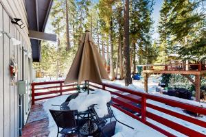 un porche con una valla roja y una sombrilla en Tahoe Twilight en Carnelian Bay