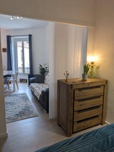 a living room with a couch and a wooden dresser at 2 pièces , Centre ville , 100 mètres des plages. in Menton