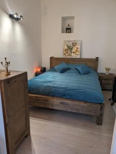 a bedroom with a wooden bed with blue sheets at 2 pièces , Centre ville , 100 mètres des plages. in Menton