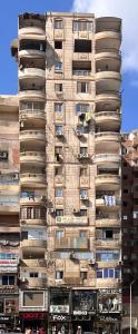 un edificio alto con gente en sus balcones en شقة فندقية قريبه من مطار القاهره الدولي, en El Cairo