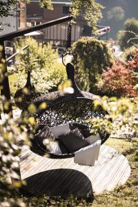 a bird bath sitting on a bench in a garden at DER MESNERWIRT - 4 Superior - Meraner Land in Avelengo