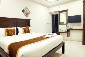 a bedroom with a large bed and a television at Rithikha Inn Crest in Chennai