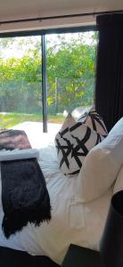 a bed with pillows on it in front of a window at Mulala Luxury Guesthouse in Thohoyandou