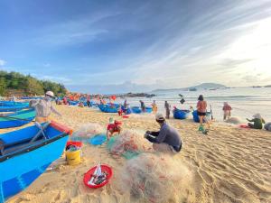 grupa ludzi bawiących się w piasku na plaży w obiekcie Kim vàng homestay w mieście Tuy An