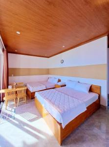 1 dormitorio con 2 camas y mesa. en Kim vàng homestay en Tuy An