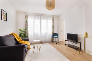 a living room with a couch and a tv at Apparemment Cosy Paris CDG Stade Expo in Aulnay-sous-Bois +5 photos