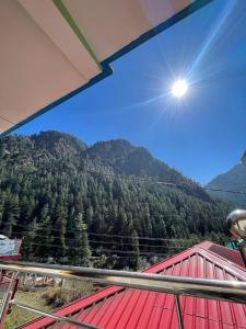 einen Blick auf einen Berg mit der Sonne im Himmel in der Unterkunft Trippy Trails in Kasol