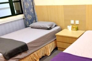 Cette petite chambre comprend deux lits et une commode. dans l'établissement Spacious & Cozy Riverine Getaways, à Kuching