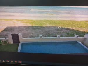 a flat screen tv with a view of a beach at Happy Beach House in Chennai
