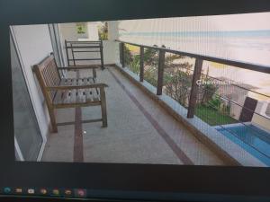 d'un balcon avec un banc et une vue sur l'océan. dans l'établissement Happy Beach House, à Chennai