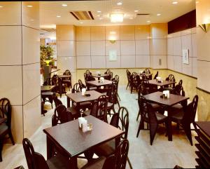 a restaurant with tables and chairs in a room at Okayama Ekimae Universal Hotel in Okayama