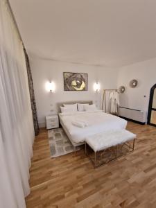 1 dormitorio con 1 cama blanca grande y suelo de madera en Rokebea Luxury, en Brasov