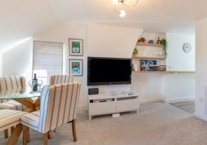 a living room with a tv and a table and chairs at 2B Pen Y Bont in Abersoch