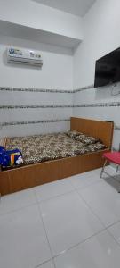 een kamer met een bed en een tv aan de muur bij NHÀ NGHỈ BÌNH DÂN SỐ 3 in Bạc Liêu