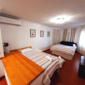 een slaapkamer met 2 bedden en een houten vloer bij Casa Blanca de La Sierra hasta 24 hasta personas con Piscina Salina y Bbq in Pelayos de la Presa