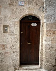 a wooden door in a stone wall with a sign above it at Arco Sallustio 2.0 in Monopoli