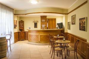 a restaurant with a bar with tables and chairs at Hotel Valentino in Acqui Terme