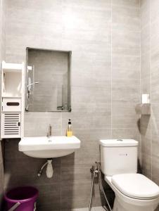 ein Badezimmer mit einem WC, einem Waschbecken und einem Spiegel in der Unterkunft Business Getaways Suite 3 pa @ Riverine Kuching in Kuching