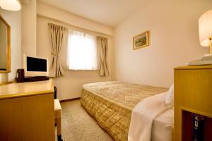 a hotel room with a bed and a window at Kurashiki Ekimae Universal Hotel in Kurashiki
