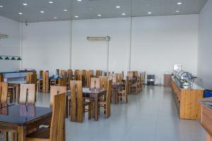 comedor con mesas y sillas de madera en New saniro airport sports hotel, en Gampaha
