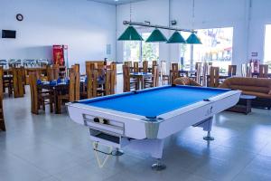 una mesa de billar en una habitación con mesas y sillas en New saniro airport sports hotel, en Gampaha
