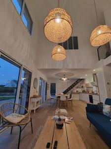 sala de estar con 2 lámparas de araña y sofá azul en Hébergement Penmarch 800 m plage, 10 mn La Torche, en Penmarch