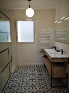 uma casa de banho com um lavatório e um espelho em Hébergement Penmarch 800 m plage, 10 mn La Torche em Penmarcʼh