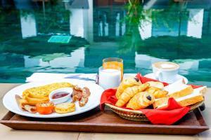 una mesa con dos platos de comida y vasos de leche en Green Amazon Residence Hotel en Siem Riep